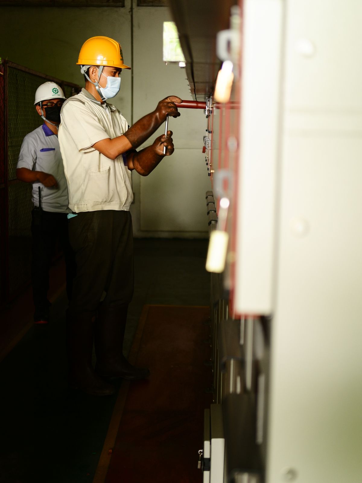 Two electricians wiring commercial control panels on a fit-out job
